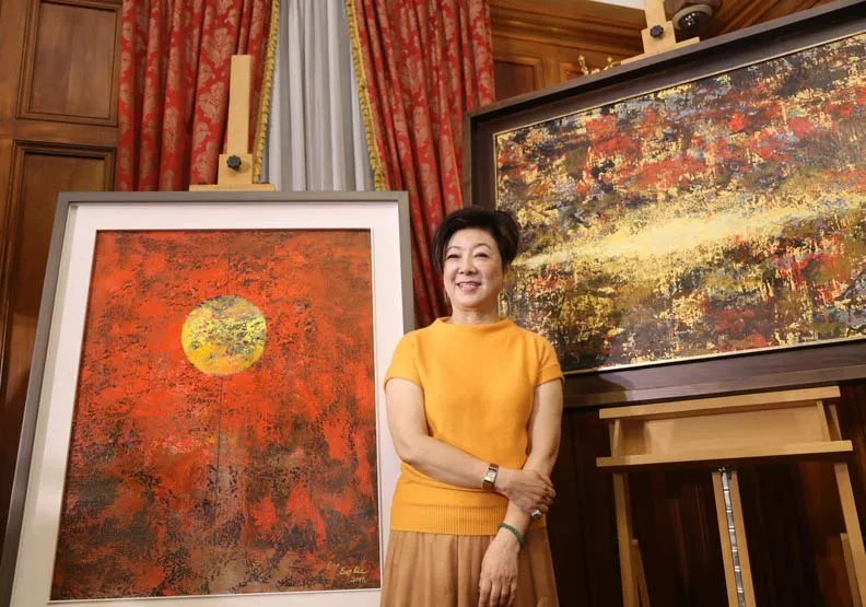台積電慈善基金會董事長張淑芬和她的畫作《祝福》（右）與《希望之鎖》（左）。
