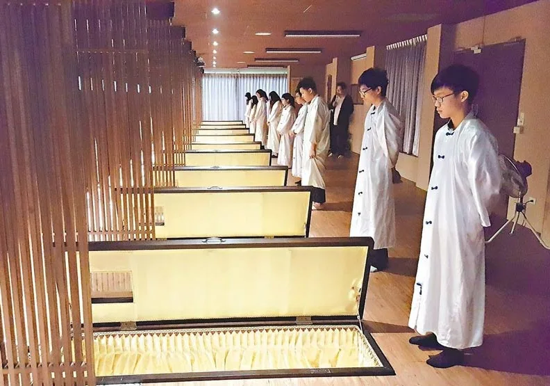 仁德醫專生命事業關懷科學生參加死亡體驗活動，包括寫遺書、躺棺木。
