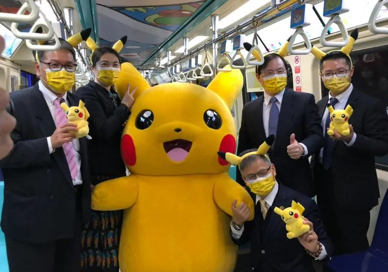 群創與北捷經營層在寶可夢主題車廂開幕時與皮卡丘公仔合照。瞇著眼，抱皮卡丘左手買萌的是群創總經理楊柱祥。白育綸攝