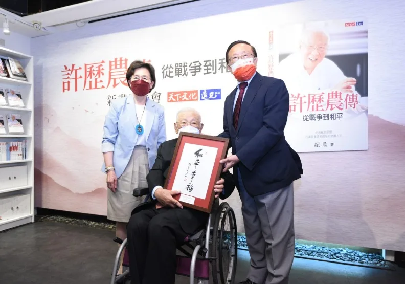 2022年7 月7日《許歷農傳》新書發表會，高希均（右）和王力行（左）贈許歷農將軍（中）星雲大師一筆字「和平幸福」。