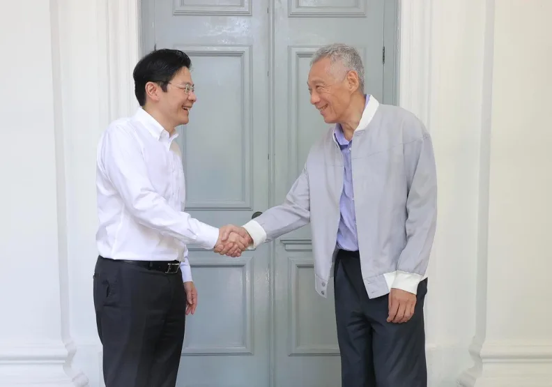 第四任總理黃循財（左）從執政20年的李顯龍（右）手中接下重擔，將率領新內閣展開他的時代。取自臉書@Lawrence Wong 