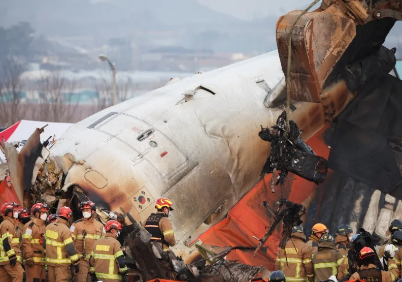 濟州航空一架班機降落韓國務安國際機場時，衝出跑道撞護欄起火，火勢撲滅後消防隊進行搜救。取自路透社。