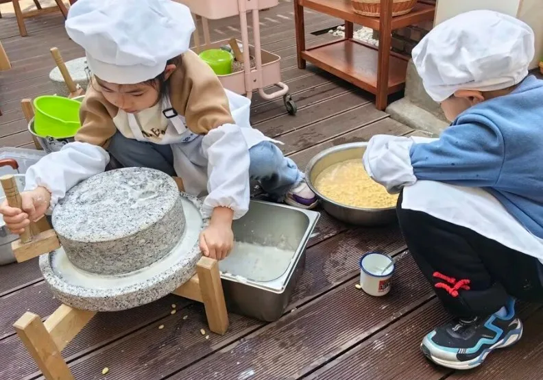 幼兒園內孩子體驗磨豆漿。取自山東宣傳微信公眾號