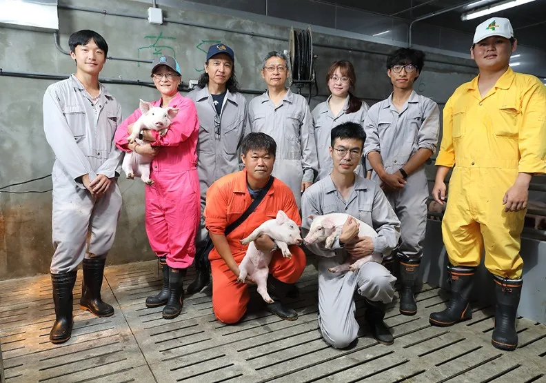 屏科大獸醫學院院長邱明堂（後排中間）領軍跨域團隊，打造全台首座AI智慧豬舍，以精準數據監控徹底翻轉傳統養豬業刻板印象。