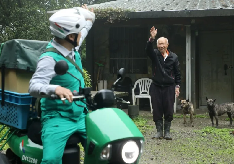 送信成了日常關懷的起點，96歲蔡伯伯（右）是郵務士陳建學最熟悉的「收件人」。張智傑攝